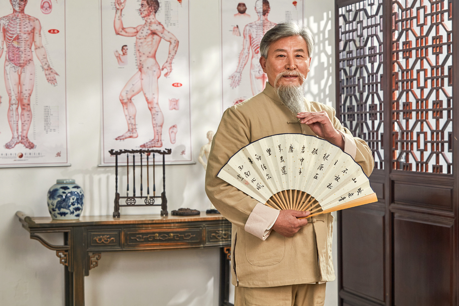 老中医拿着扇子的肖像照片