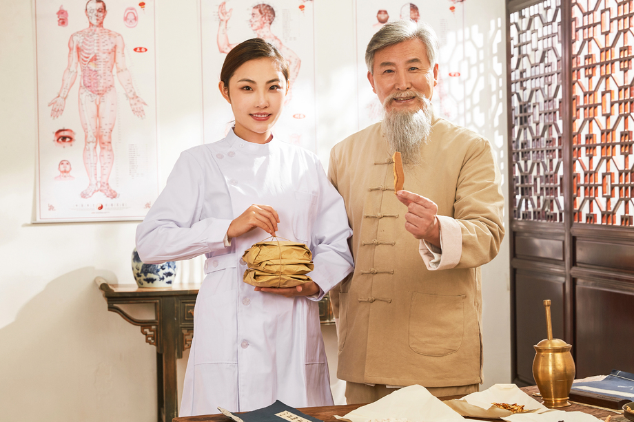 拿着药包的年轻医生和展示药材老中医的肖像 拿着药包的年轻医生和展示药材老中医的肖像