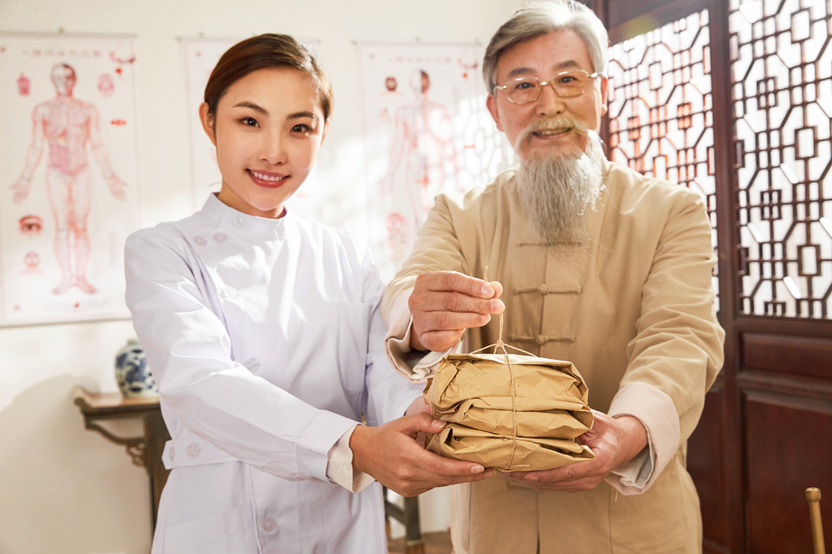 老中医和年轻医生拿着药包 老中医和年轻医生拿着药包