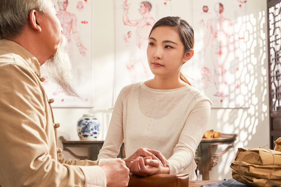 年轻病人接受老中医的诊脉