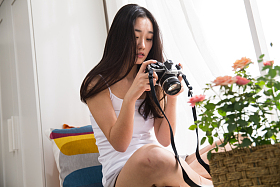 青年女人拿着相机拍照