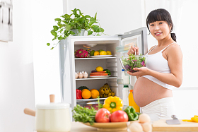 孕妇打开冰箱拿蔬菜