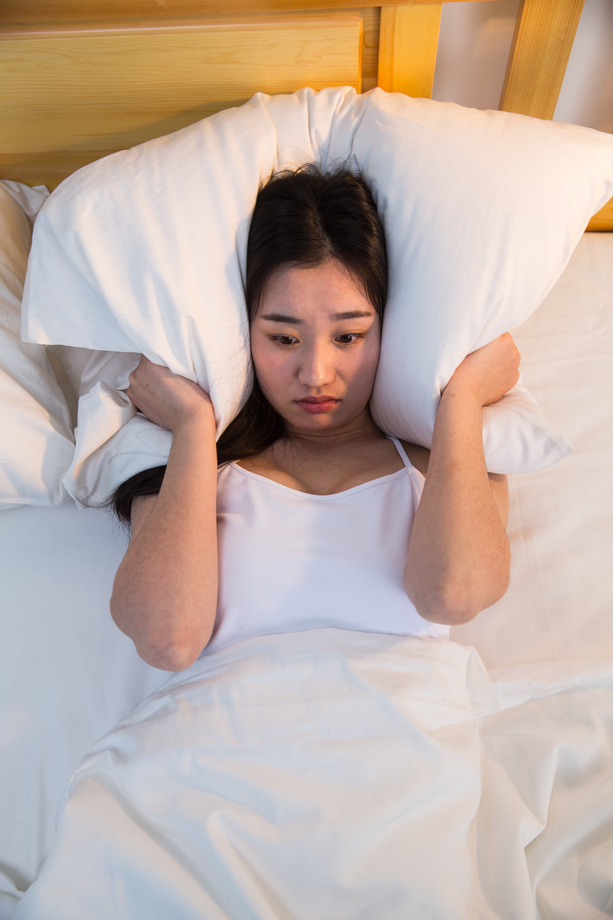 情绪低落的青年女人在卧室的床上 情绪低落的青年女人在卧室的床上