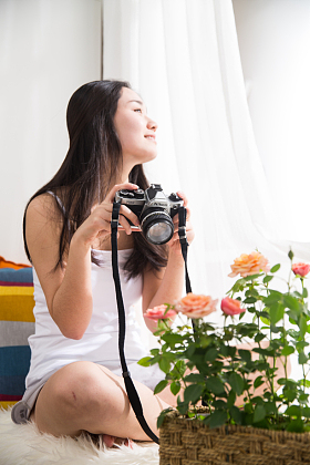 青年女人拿着相机拍照图片