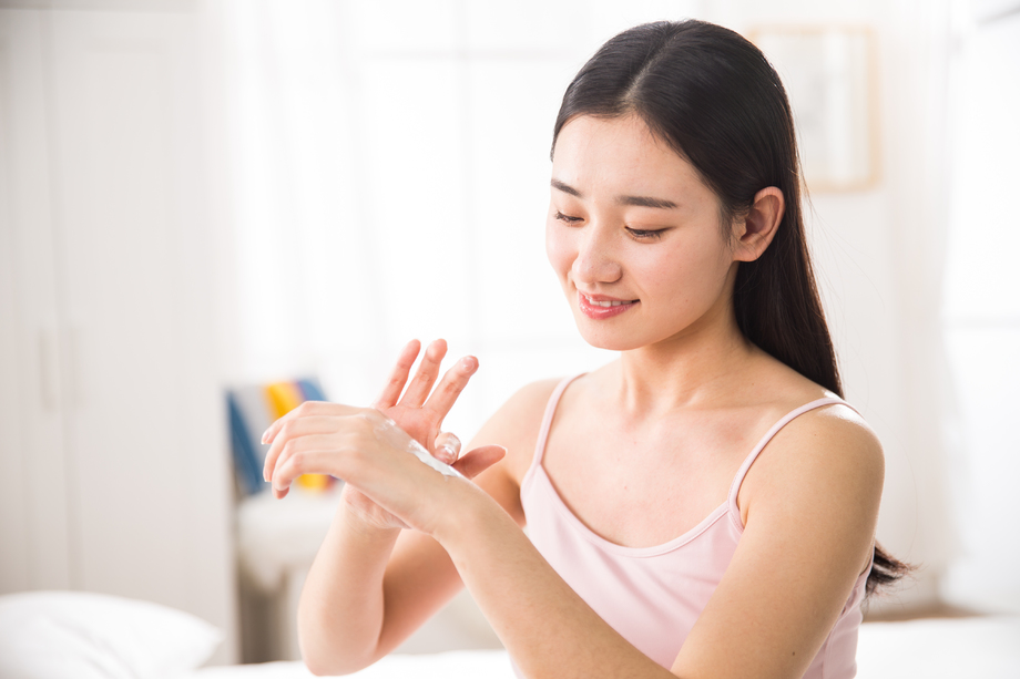 青年女人涂抹润肤露