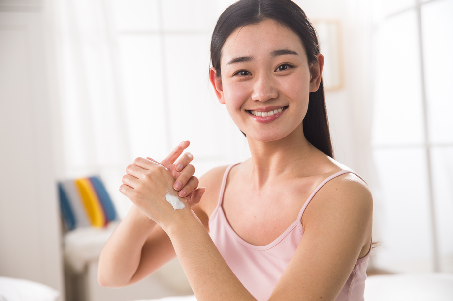 青年女人涂抹润肤露