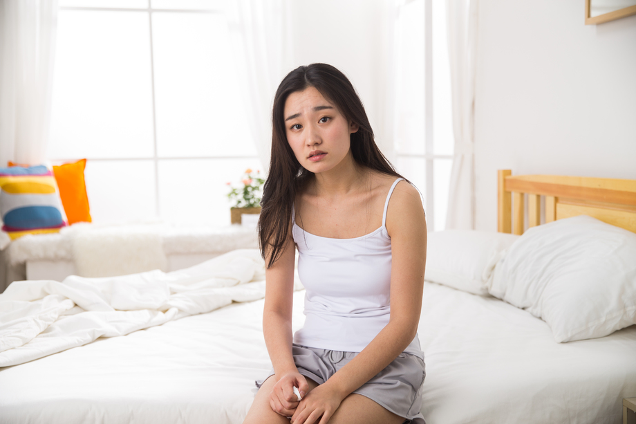 青年女人坐在床上图片
