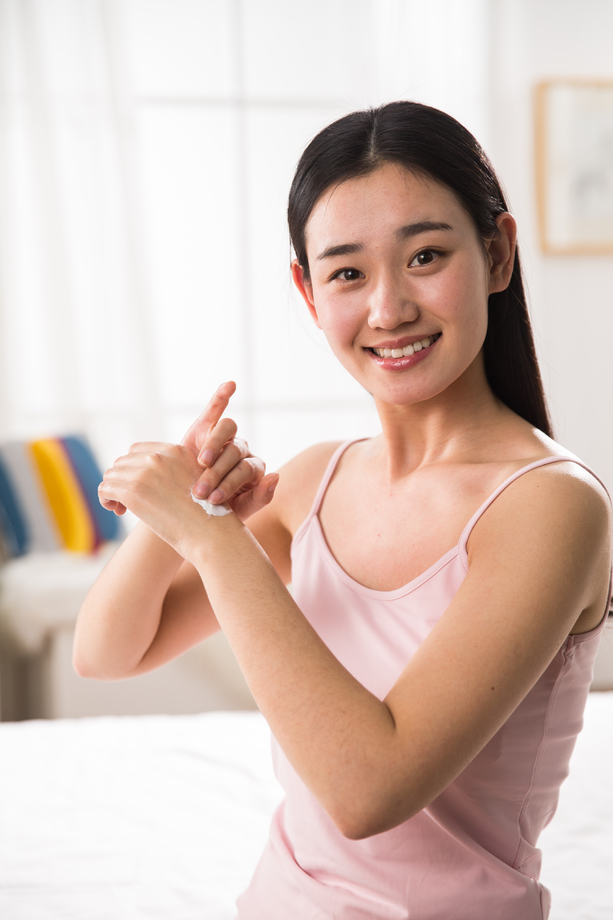 青年女人涂抹润肤露 青年女人涂抹润肤露