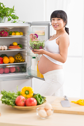 孕妇打开冰箱拿蔬菜