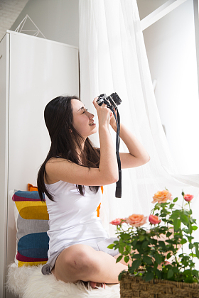 青年女人拿着相机拍照图片