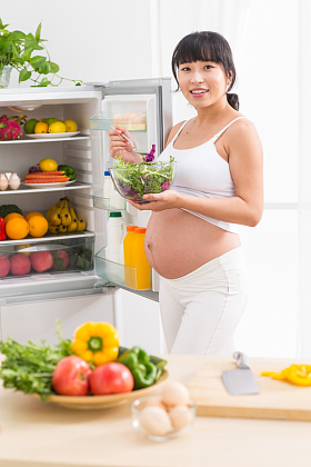 孕妇打开冰箱拿蔬菜图片