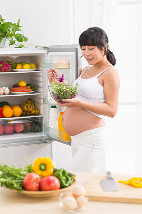 孕妇打开冰箱拿蔬菜图片