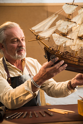 老年男人在制作帆船模型图片