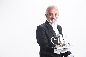 一个男侍者托着银餐具