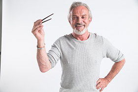 老年男人拿着筷子