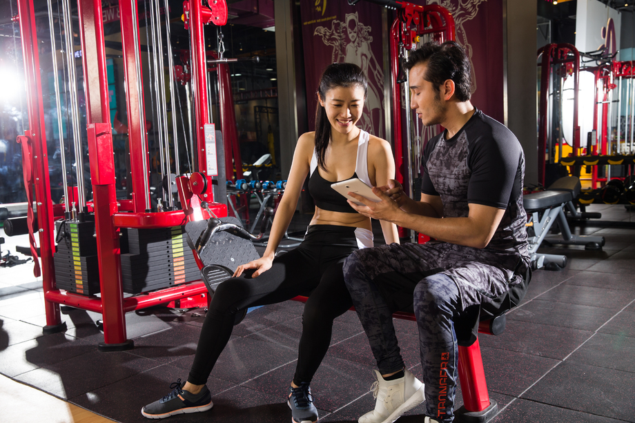 青年女人和教练看平板电脑