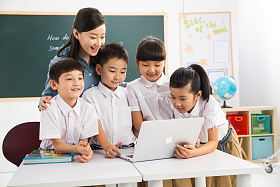 教师和小学生在教室里使用电脑