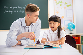 老师在指导小学生学习图片