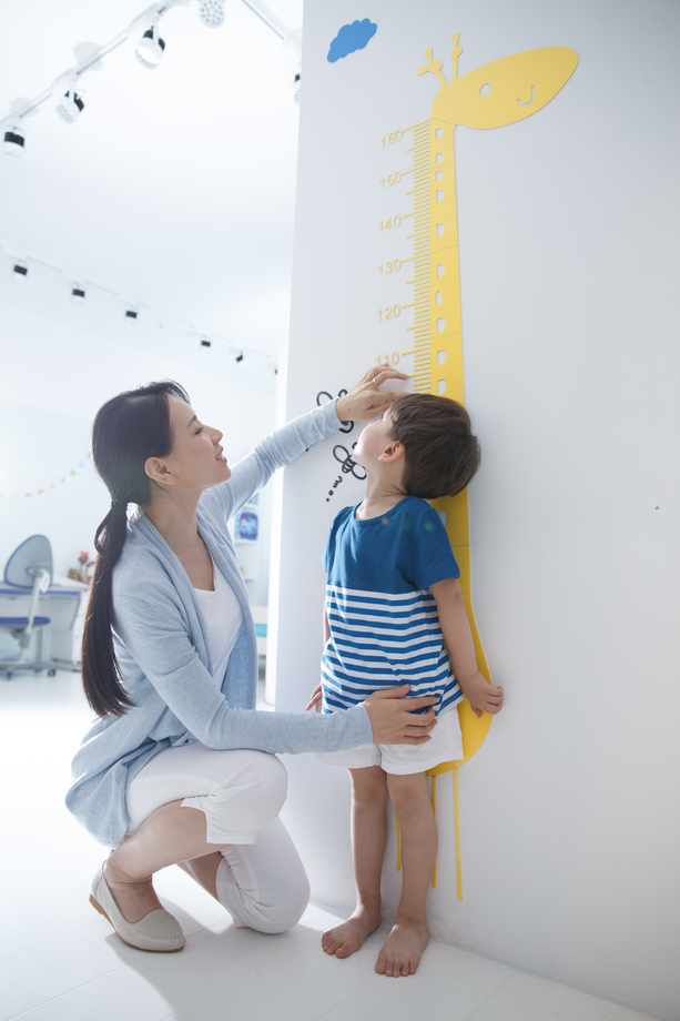 青年女人在为小男孩测量身高图片 青年女人在为小男孩测量身高图片