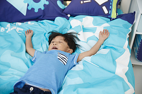 可爱的小男孩在床上玩耍照片