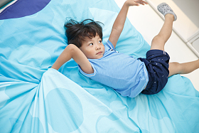 可爱的小男孩在床上玩耍图片