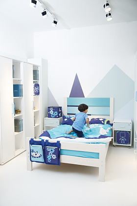 可爱的小男孩在床上玩耍照片