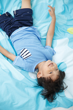 可爱的小男孩在床上玩耍图片