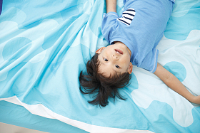 可爱的小男孩在床上玩耍图片