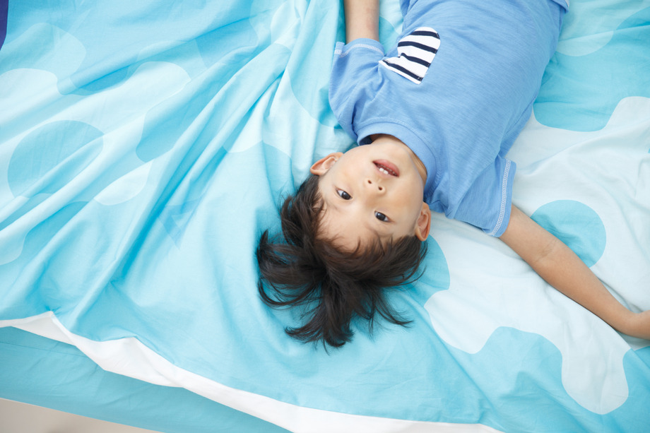 可爱的小男孩在床上玩耍图片