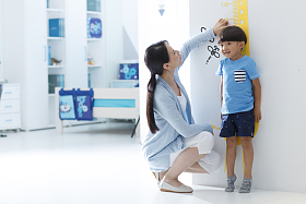 妈妈在为小男孩测量身高图片