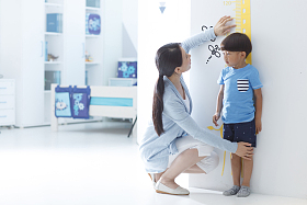 妈妈在为小男孩测量身高