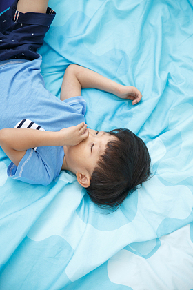 可爱的小男孩在床上玩耍图片