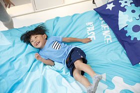 可爱的小男孩在床上玩耍图片