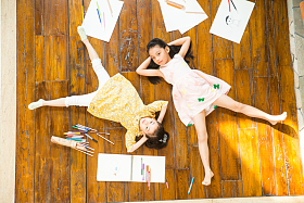 姐妹俩躺在地板上玩耍