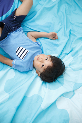 可爱的小男孩在床上玩耍图片