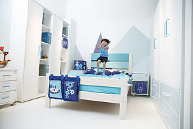 可爱的小男孩在床上玩耍照片