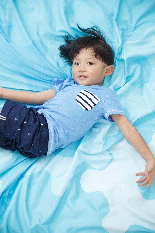 可爱的小男孩在床上玩耍 可爱的小男孩在床上玩耍