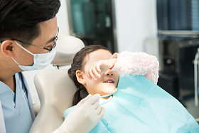 男牙医在为小女孩检查牙齿图片