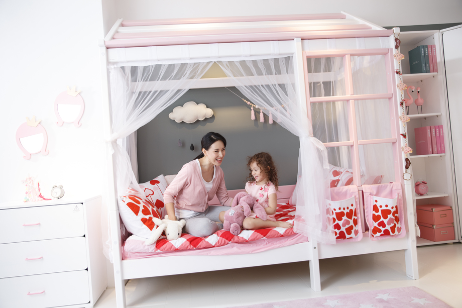 可爱的小女孩和妈妈在卧室玩耍