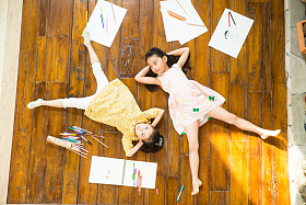 姐妹俩躺在地板上玩耍照片