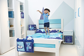 可爱的小男孩在床上玩耍照片