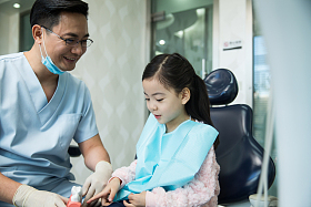 男牙医在为小女孩检查牙齿