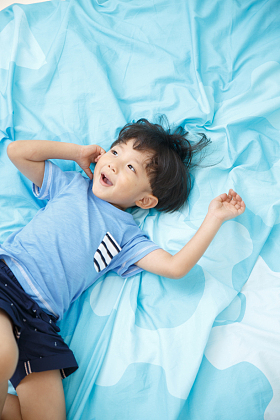 可爱的小男孩在床上玩耍图片