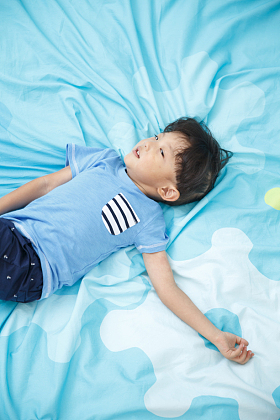 可爱的小男孩在床上玩耍图片