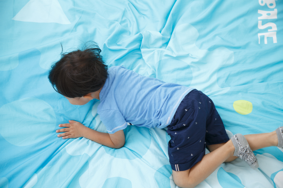 可爱的小男孩在床上玩耍 可爱的小男孩在床上玩耍