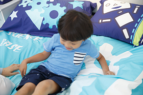 可爱的小男孩在床上玩耍图片