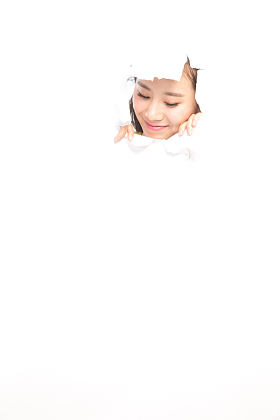 青年女人通过纸洞窥视照片