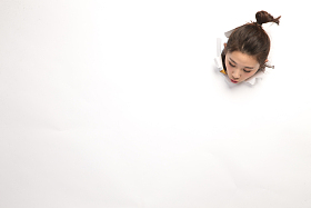 青年女人通过纸洞窥视