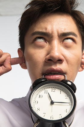 商务青年男人拿着闹钟