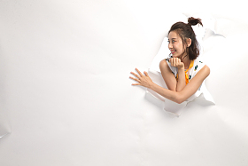 青年女人通过纸洞窥视照片